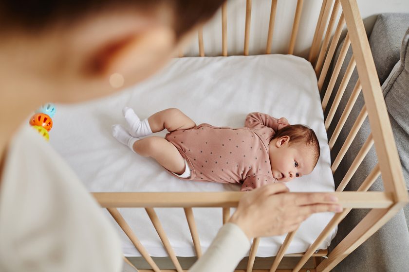 Resources 91 Over the shoulder shot of baby lying in crib while mum looks down at baby, top view
